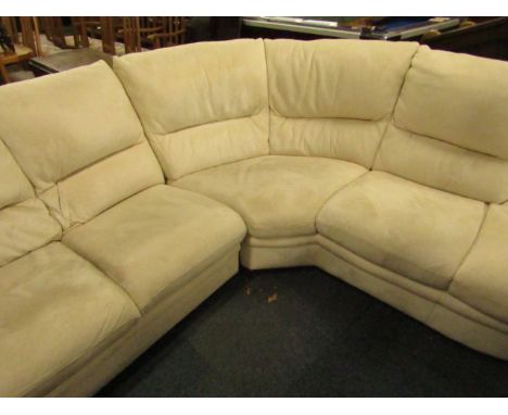 A four seater corner sofa upholstered  in faux cream suede, approx 230cm long.