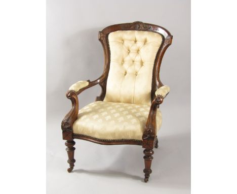 A Victorian mahogany armchair with carved crest rail, button back patterned fabric with overstuffed seat, scrolling arms, rai