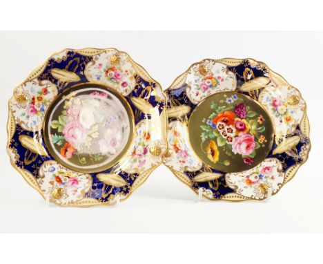 A pair of early 19thC porcelain plates painted centrally with flowers, against a cobalt blue ground, with yellow and gilt lea
