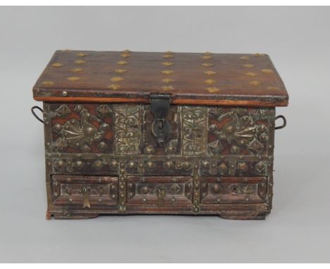 An Indian hardwood box with brass studded and overlaid decoration, three small frieze drawers, raised on bracket feet, 50cm x