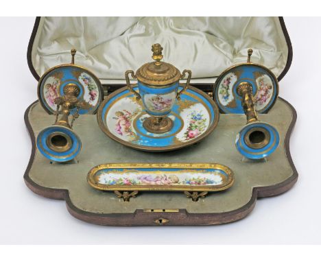 A Sèvres-style boxed desk set, 19th century, painted with panels of cherubs and flowers reserved on a turquoise ground, with 