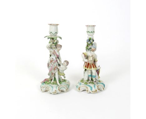 A near pair of Derby candlestick figures, c.1760, of Mars and Venus, each standing before a tall column entwined with blue fl