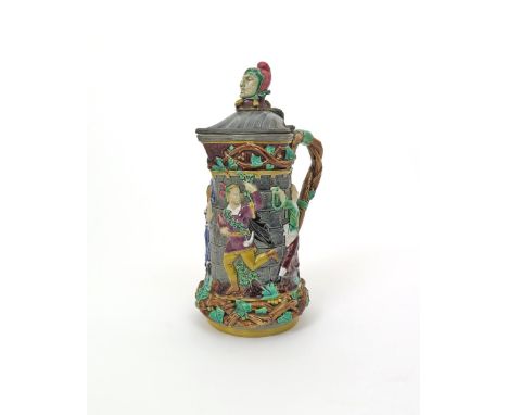 A Minton Majolica ewer, date code for 1867, moulded in high relief with four figures dancing around a stone wall, the neck an