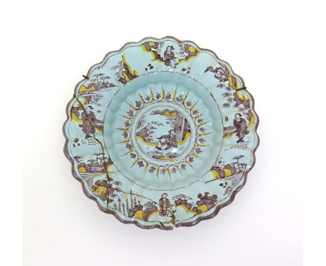 A London delftware lobed charger, c.1680, painted in yellow and manganese with a Chinese figure seated in a garden setting, t