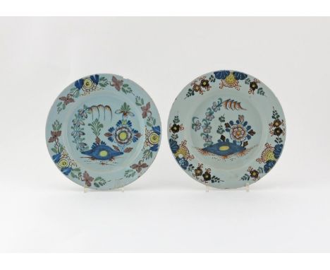 A matched pair of English delftware plates, c.1760-70, painted in polychrome enamels with Oriental flowers issuing from styli