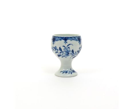 A Worcester blue and white egg cup, c.1758-60, painted with floral sprays beneath a formal border, the foot with small sprigs