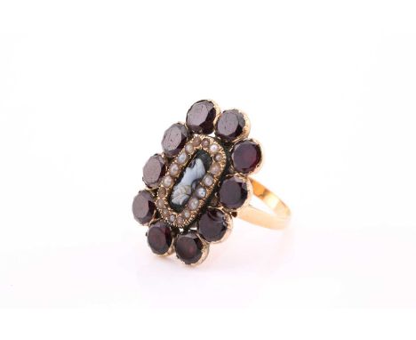 A 19th century mourning brooch converted into a ring, with a central agate cameo surrounded by a band of seed pearls and a ba