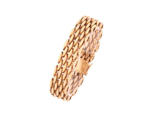 A 9ct gold brick link bracelet, comprises of seven rows of hollow faceted brick links, fastened by a box clasp secured with t