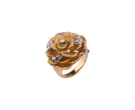 A Kutchinsky platinum and 18ct yellow gold diamond ring, comprises a flower head with layering textured petals, round brillia