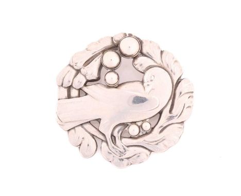 Georg Jensen - A silver brooch, depicting dove in wreath with silver dome accents, with hinged pin stem and safety catch fitt
