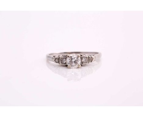 A diamond cathedral engagement ring, consisting of a round brilliant central diamond of 0.37cts, claw set on a high mount wit