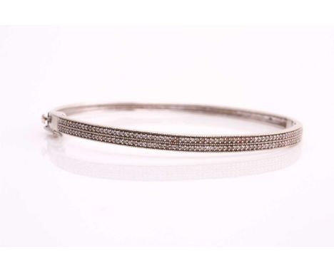 A hinged diamond bangle, one side pavé-set with two rows of round single-cut diamonds, fastened with groove and tongue clasp 