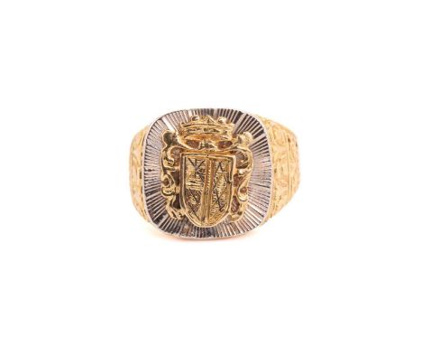 A gold signet ring, featuring a carved coat of arms with runic symbols on the escutcheon, on a bright-cut engraved sunburst p