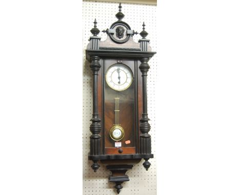 An early 20th century walnut and ebonised Vienna drop trunk wall clock