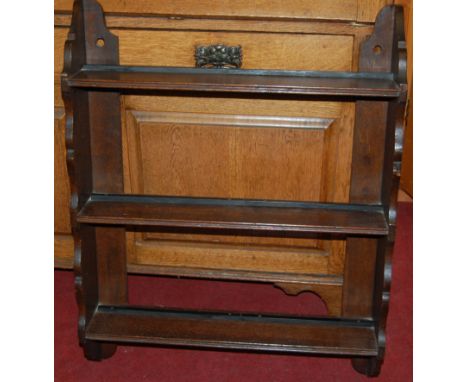 An early 20th century oak three-tier hanging wall shelf; together with an Ercol dark elm two-tier plate rack (2)
