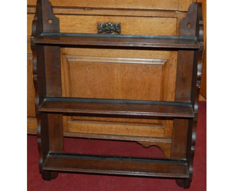 An early 20th century oak three-tier hanging wall shelf; together with an Ercol dark elm two-tier plate rack (2)