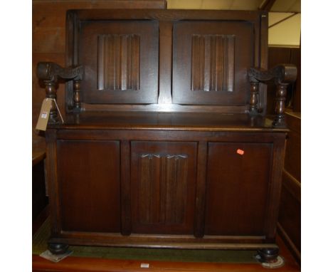 A moulded oak linenfold panelled monks bench, having foldover top to typical hinged boxseat base, w.101cm
