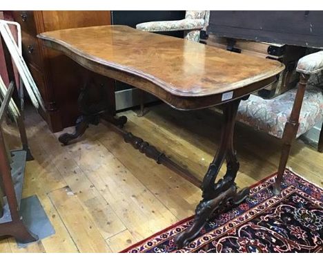 A Victorian walnut sofa table, the shaped top with moulded edge raised on twin end carved shaped supports and scroll feet (h.