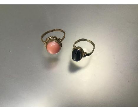 A 9ct gold pink coral set dress ring (Q) (3.46g) and a Continental yellow metal star sapphire oval cabouchon set ring (3.95g)