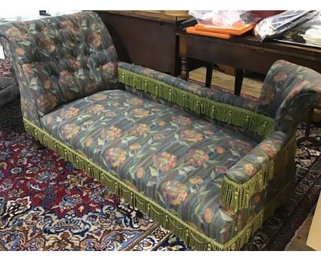 An Edwardian oak chaise longue with upholstered panel back and button scroll arm, in tapestry fabric, with green trim, raised