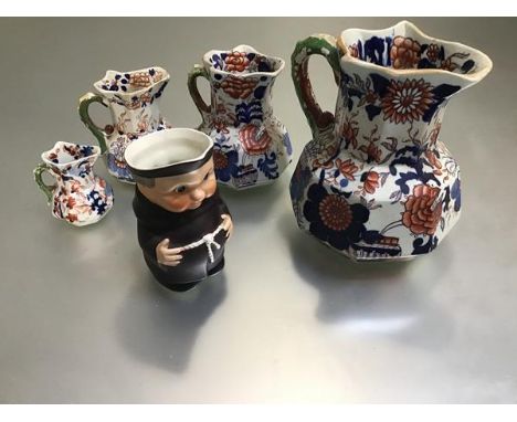 A set of four Masons Ironstone octagonal Imari decorated jugs with dragon scroll handles and a Hummel pottery figure, Monk, n