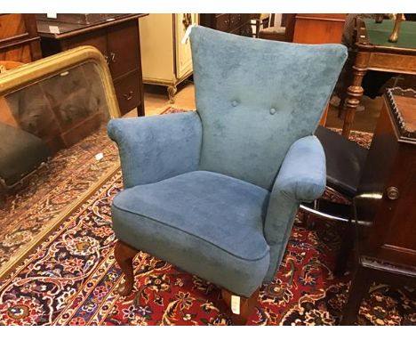 A 1950s tub chair with button back, upholstered arms and stuffover seat, in blue plush, raised on carved moulded supports and