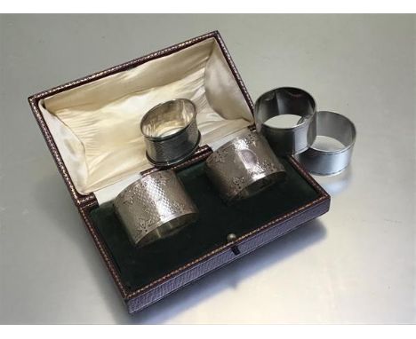 A pair of Birmingham silver engine turned napkin rings, two Epns napkin rings and a Birmingham silver oval engine turned napk