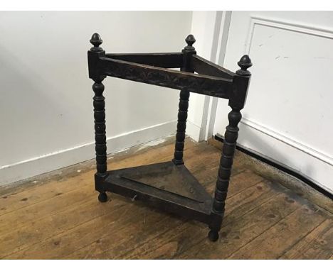 A 1930s oak carved corner stick stand with arcaded frieze raised on bobbin turned supports complete with drip pan (a/f) (h.72