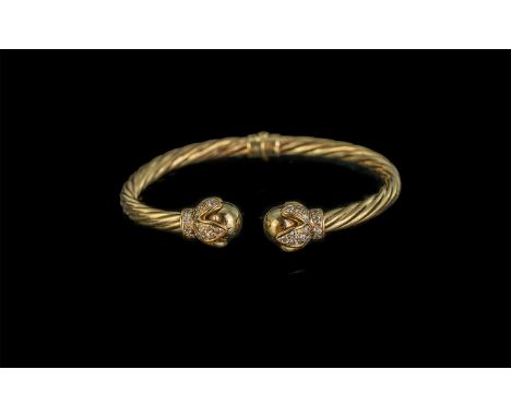 9ct Gold Hinged Torque Bangle, the terminals set with clear faceted stones.  Stamped 9k.  Gross weight 17 grams.