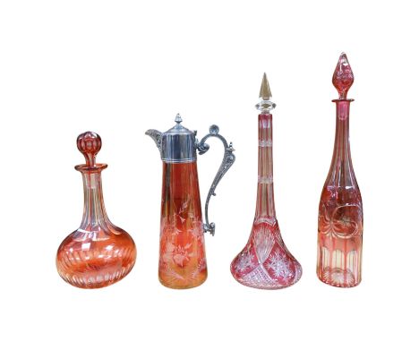 A collection of cranberry glassware comprising three decanters with stoppers and a silver plate mounted ewer, largest 41cm hi