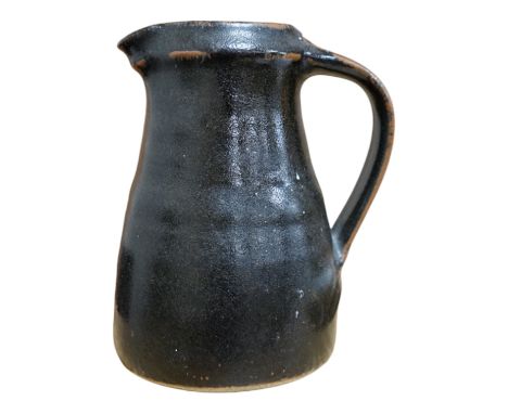 Leach standard ware, a small Stoneware black glazed studio pottery jug, impressed mark to top of foot rim, 15.5cm high. Condi