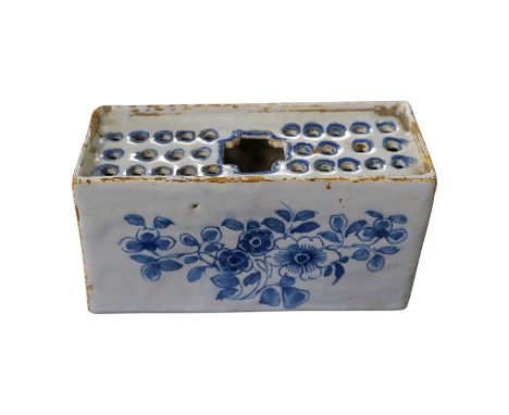 An 18th century English delftware flower brick, 15cm wide, 8cm high. Condition - edges chipped and larger chip to one corner,