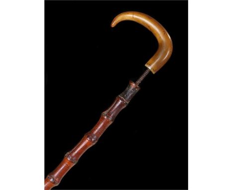 Victorian Rhinoceros horn walking stick, the carved arched head above a cane, 85cm high