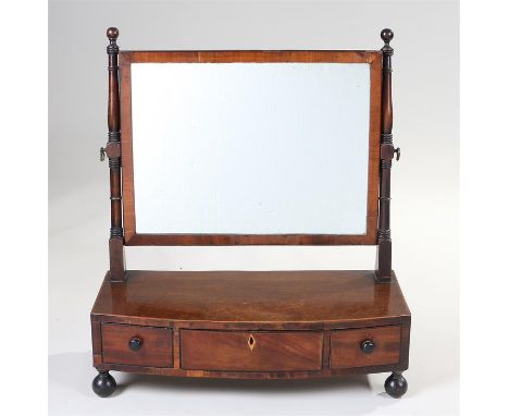 Victorian mahogany toilet mirror, the rectangular mirror plate held by turned supports above a bow fronted base with three fr