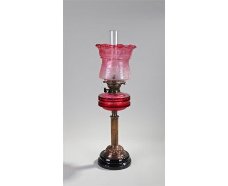Victorian oil lamp, the cranberry glass shade with etched foliate drop decoration above a cranberry glass reservoir and coppe