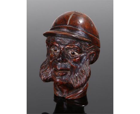 Victorian jockey head walking stick handle top, with a carved cap above glass eyes and wide sideburns, 8cm high