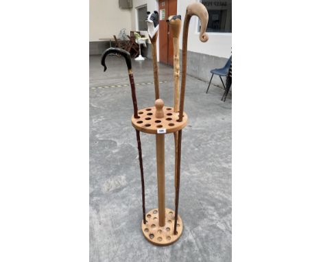 A beechwood snooker cue stand with four walking sticks