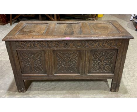 A late 17th century joined oak carved three panel chest, raised on stiles. 48' wide