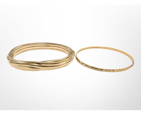 A 9ct yellow gold bangle with metal core, together with a Continental yellow metal bangle. (2) CONDITION REPORT: Thin yellow 