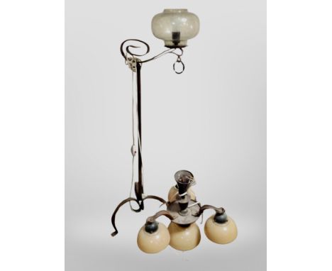 A Scandinavian wrought metal standard lamp and a further pendant light fitting with opaque glass shades 