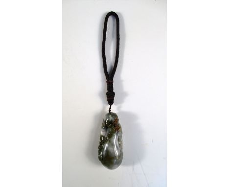 A jade hand pendant, the mottled green stone with toffee brown inclusions pierced and carved as a mythical beast with lingzhi