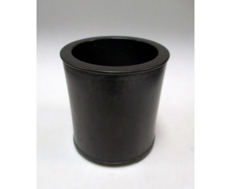 A zitan brush pot, the cylindrical shape with rims in slight relief to the exterior, on three shallow bracket feet, 13cm (5.2