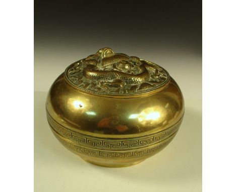 A polished bronze box and cover, the lid of the bun shaped body cast with a dragon encircling the sacred pearl, the rims with