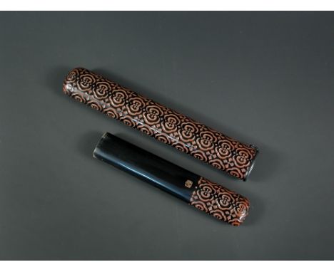 A 19th century guri lacquer pipe case, the black lacquer exterior carved with hexafoils into the underlying red, the interior