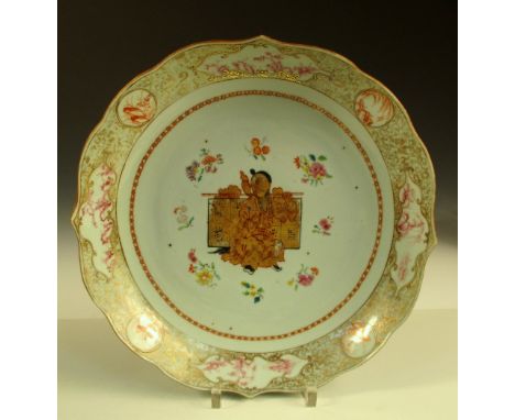 An 18th century dish, later European gilt with a central figure, the barbed rim enclosing a gilt scroll band with alternating