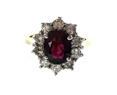 RUBY AND DIAMOND RING, set with a central oval faceted ruby of approximately 2.00 carats within a diamond halo, the diamonds 