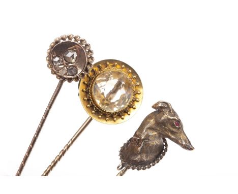 THREE VICTORIAN STICK PINS, comprising one mounted with the head of a greyhound modelled in the round and with gem set eyes, 