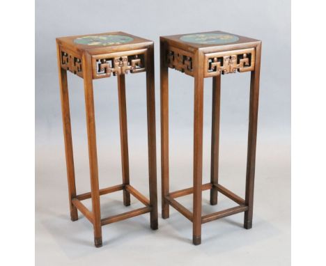 A pair of Chinese hardwood vase stands, each inset with cloisonne panels depicting birds on a branch and flowers in a jardini