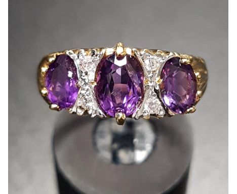 AMETHYST AND DIAMOND DRESS RINGthe three graduated oval cut amethysts separated by small diamonds, on eighteen carat gold sha