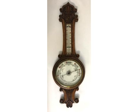 OAK FRAMED ANEROID BANJO BAROMETERthe carved case with thermometer above a circular dial, 87cm long 